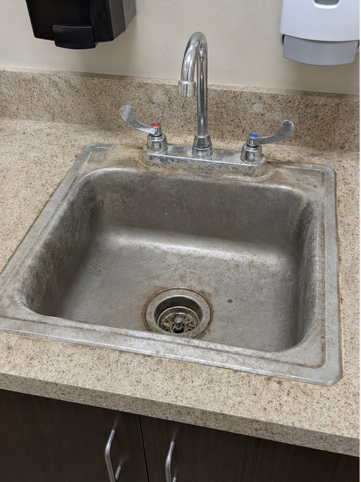 Stained commercial kitchen sink before cleaning